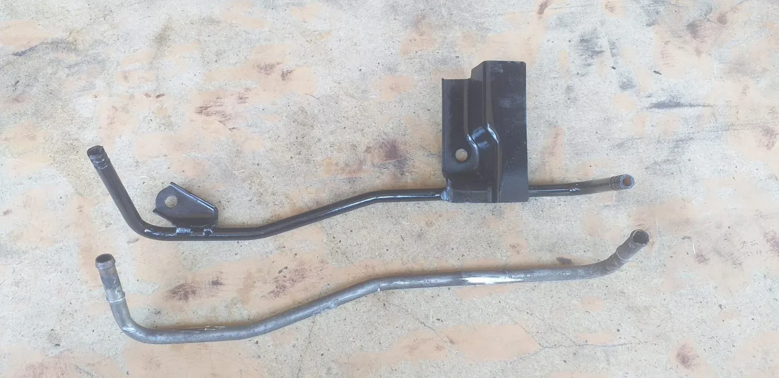 Sistema de refrigeración automotriz antes y después: cañería vieja vs nuevo sistema completo con soporte fabricado en Tubotec Santiago